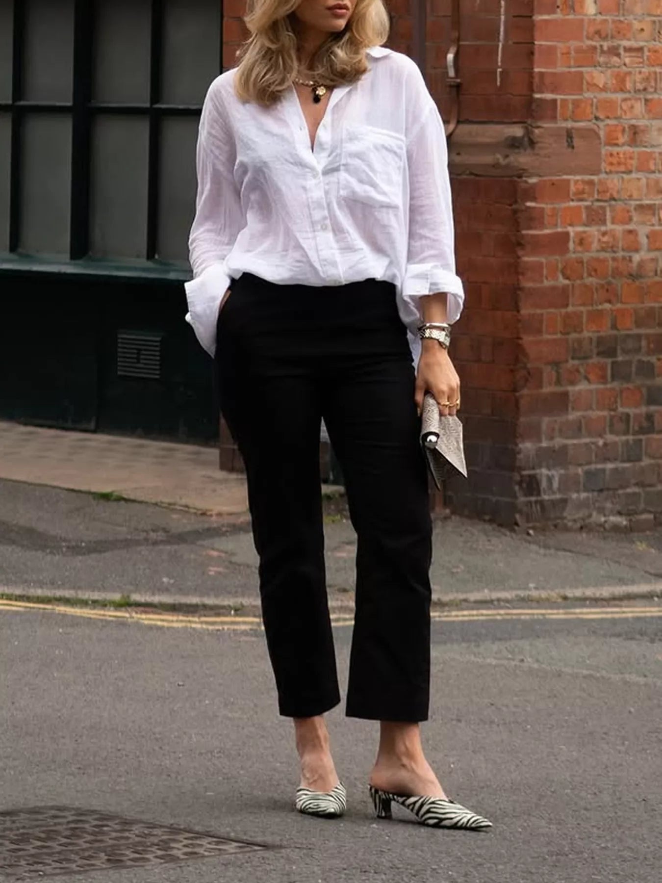 White textured women’s button down shirt styled with tailored black pants for business casual look
